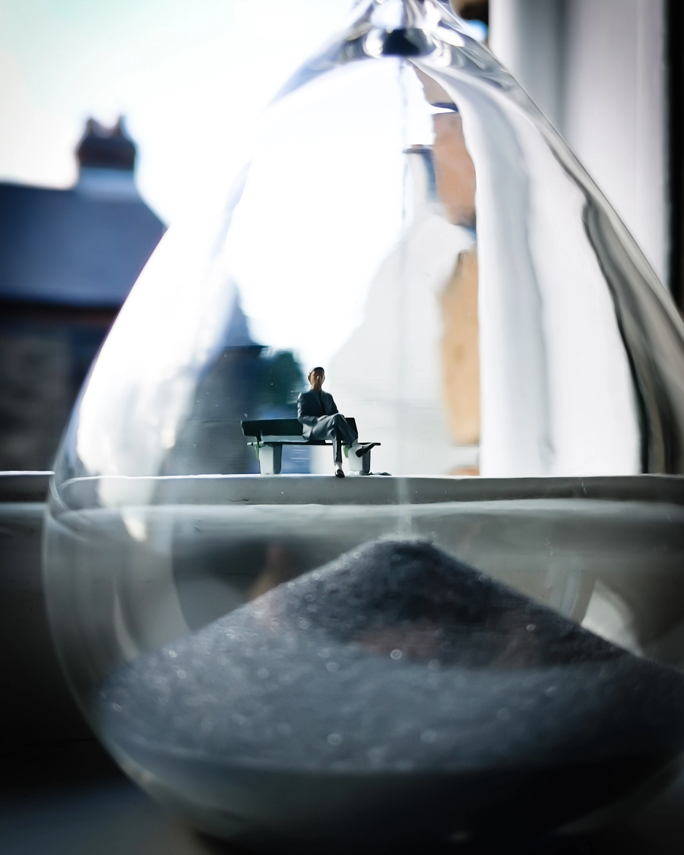 man sitting on a chair with picture taken trought a glass