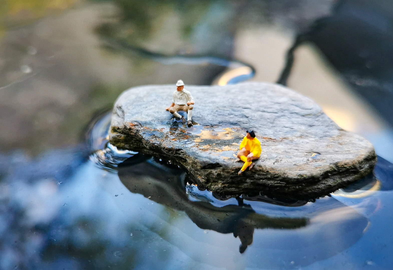 Father and son sitting on a rock